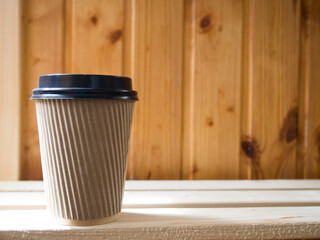 paper cup of coffee on wooden background