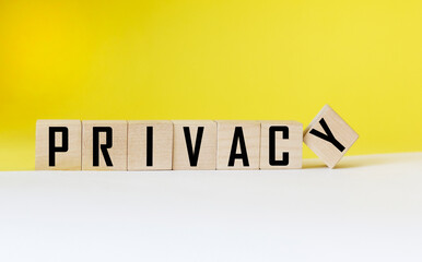 Privacy word on wooden cube and white and yellow background.