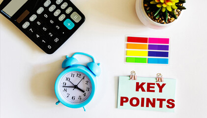 Sticker with the text KEY POINTS, next to a calculator, a cactus clock on a white background
