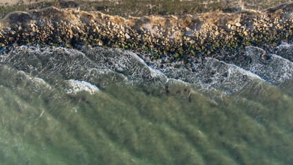 Rocky seashore, waves, dirt road. Aerial view. Aerial photography.