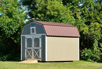 Fototapeta na wymiar Outdoor storage shed. American shed is typically a simple, single-story roofed structure in a back garden or on an allotment that is used for storage, hobbies, or as a workshop. 