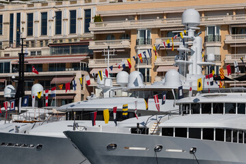 A lot of huge yachts are in port of Monaco at sunny day, Monte Carlo, mountain is on background,...