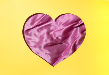 Heart from silk on a yellow background. Flat lay. Minimal love concept ideas for Valentine's Day