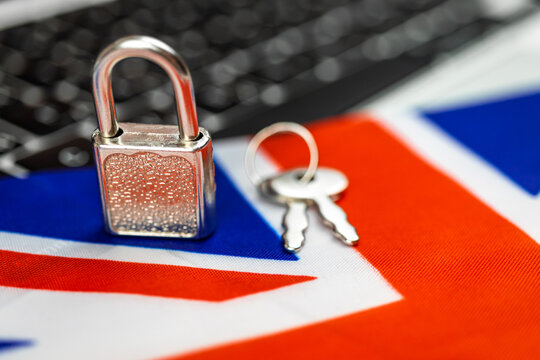 United Kingdom cyber security concept. Padlock on computer keyboard and UK flag. Close-up view photo