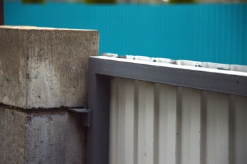 Gray metal gate attached to a stone fence