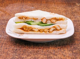 chicken tikka sandwich in a dish on dark wooden background side view