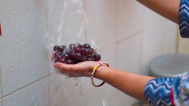 Close up shot of womans hands wahing fruits under tap water at home kitchen. Hygiene, health care and safety concept
