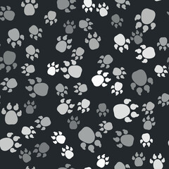 Fototapeta premium Grey Paw print icon isolated seamless pattern on black background. Dog or cat paw print. Animal track. Vector