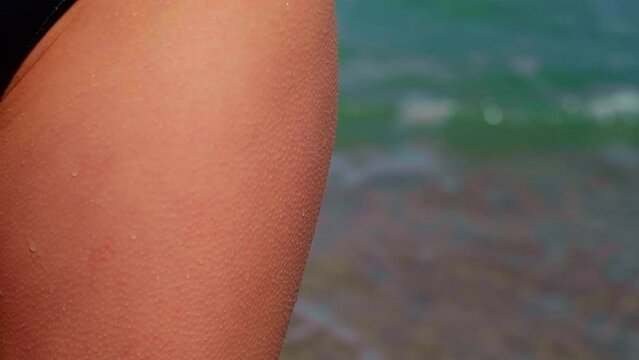 Goosebumps on a woman thighs. Cold sea water at the beach.