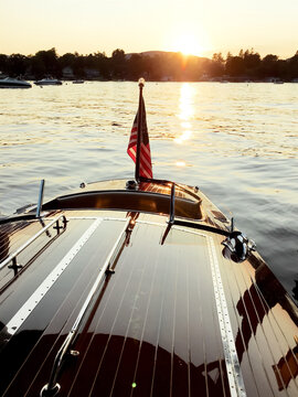 Sunset on Lake with American Flag at the back of wooden boat.