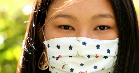 Close-up Asian woman face wearing face mask looking at camera