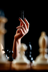 Woman playing chess and holding black queen in hand