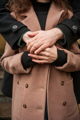 Married couple in love holding hands walking through city in early spring