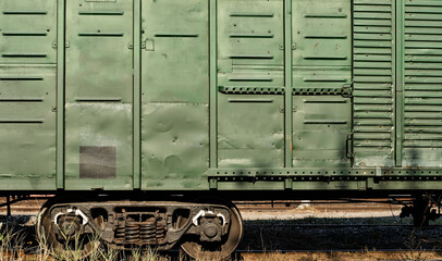 Part of green freight car (railway carriage) including chassis (side frame, suspension with wheels,...