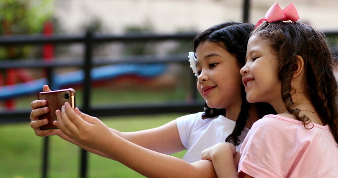 Children taking selfie with cellphone, pre-teen girls take selfie