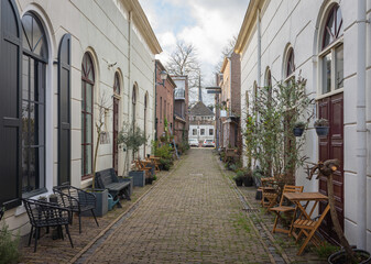 Fototapeta na wymiar Beautiful, old, cobbled street with chairs and pot plants nearby historical centrum of dutch city of Gorinchem