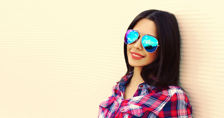 Naklejka premium Portrait of beautiful happy smiling young brunette woman in sunglasses on white background