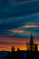 sunset in the mountains with tree silhouette