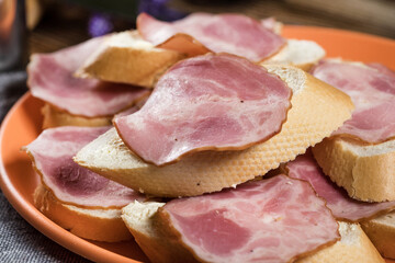 Sandwich made of wheat bread, butter and slices of dry-cured sausage.