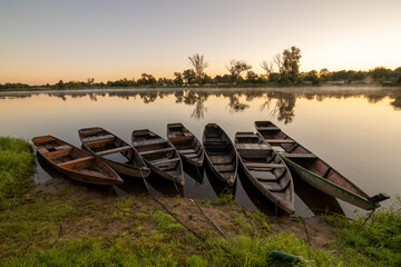 Wschód słońca nad Bugiem z łódkami