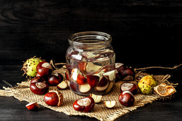 Preparation of alcohol tincture from fresh horse chestnuts. Chestnuts in a jar of alcohol