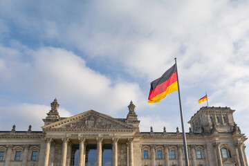Facade of the German Parliament with the German flag fluttering.