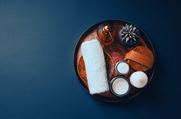 Perfect Spa still life with a natural cosmetic products, candles and flower on a copper plate.