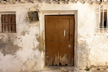 facade with antique wooden door in Spanish village house