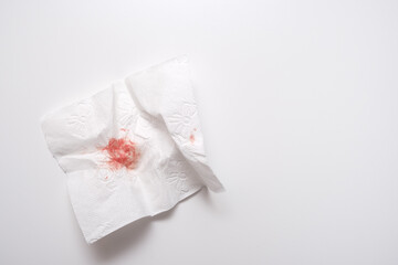 Fototapeta na wymiar Blood on used toilet paper on white background, anal bleeding and hemorroidis concept