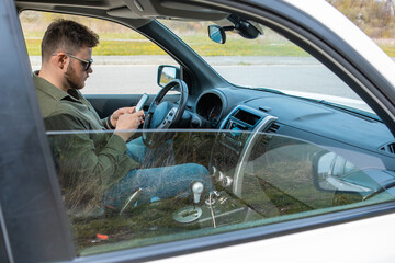 man sitting in car using phone