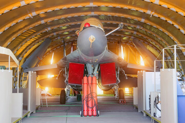Wing military fighter with folded wings in the garage of the hangar on service repair.