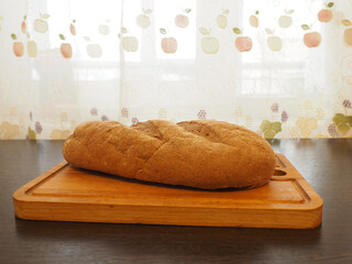 Loaf of bread sprinkled with flour on a cutting board