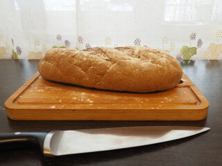 Loaf of bread sprinkled with flour on a cutting board