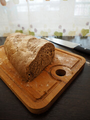 Loaf of bread sprinkled with flour on a cutting board