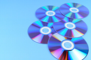 Several CD roms lie on a horizontal surface.