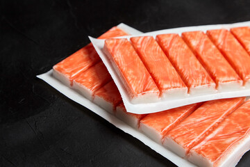 Crab sticks or imitation crab meat on black table © mikeosphoto