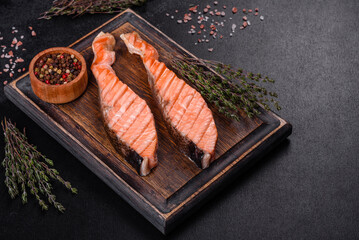 Grilled salmon with herbs served on black concrete table