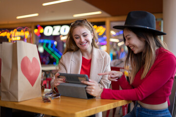 two women in cafe searching in the tablet