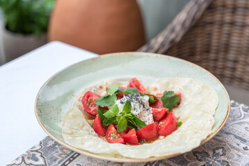 Tomato and Fresh Cheese Salad with Cilantro, Mint and Black Salt Flakes Served on Flatbread