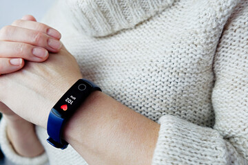 Close-up of a woman's high heart rate fitness tracker. Tachycardia after coronavirus. Selective focus.