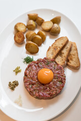 Classic Beef Steak Tartare with Egg Yolk, Fried Baby Potatoes and Toasted French Bread