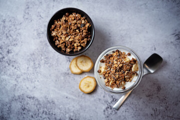 Banana Greek yogurt chocolate granola parfait in a glass