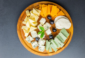 cheese plate food with dor blue cheese and brie with grapes on wooden background