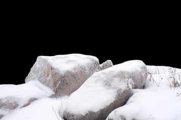 natural stone in snow isolated on black background