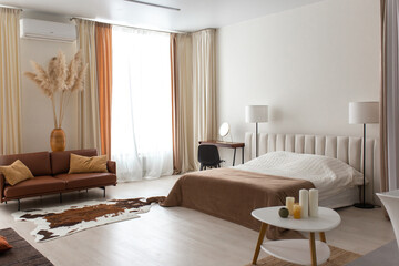 Home interior with ethnic boho decoration, living room in brown warm color