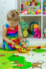 Fototapeta premium Baby plays with toys in the room. Selective focus.
