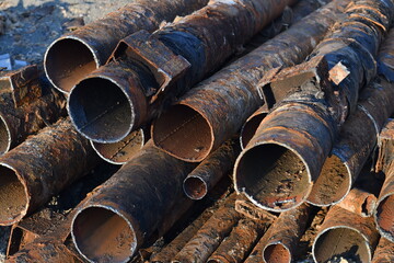 Used rusty metal pipes taken out of the ground. Renovation works. Selective focus.