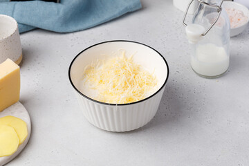 Step-by-step recipe of potato gratin. Hands hands pour salt to bowl for the sauce. Potato casserole