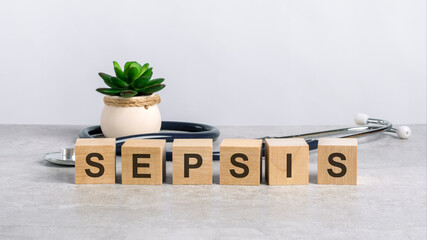 sepsis word written on wooden blocks and stethoscope on light gray background