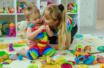 Fototapeta premium Baby plays in the room with her mother. Selective focus.